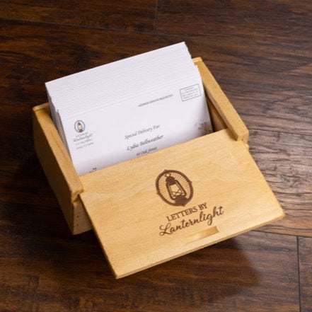 Wooden box with 'Letters by Lanternlight' branding on a wooden surface
