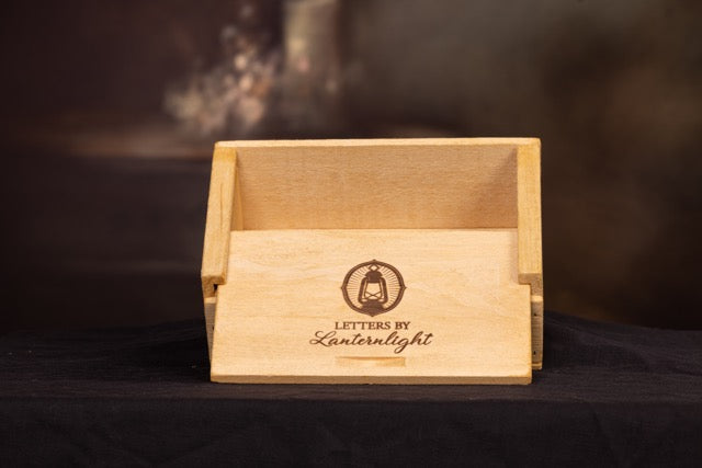Wooden box with 'Letters by Lanternlight' branding on a dark background